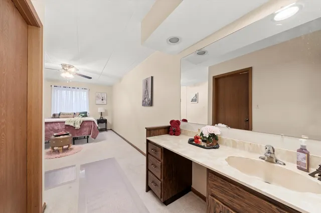 a bathroom with double vanity sinks a mirror and a painting on the wall