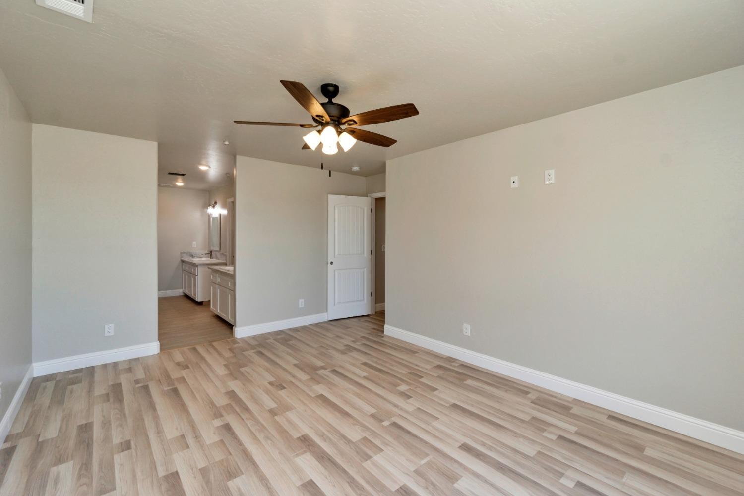 21250 Steward Road Madera, CA 93638 - Photo 19 of 40 a view of an empty room with wooden floor and a ceiling fan