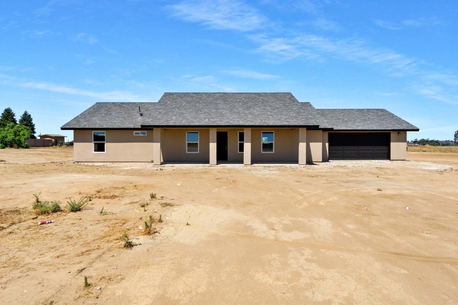 21250 Steward Road Madera, CA 93638 - Photo 3 of 40 a front view of a house with a yard