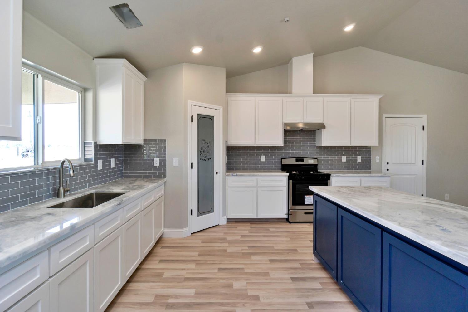 21250 Steward Road Madera, CA 93638 - Photo 10 of 40 a kitchen with a sink stove top oven and refrigerator