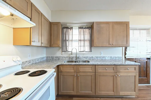 a kitchen with granite countertop a sink and cabinets