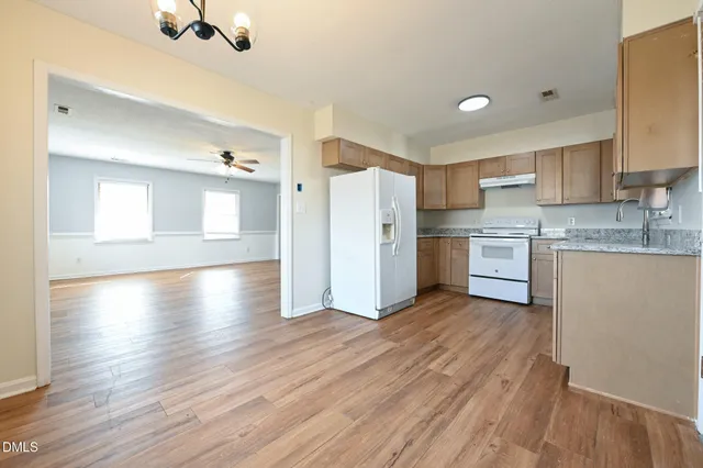 a view of kitchen with wooden floor electronic appliances and window