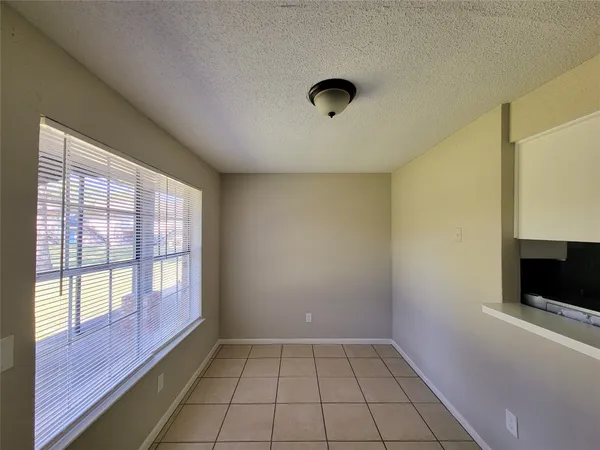 a view of an empty room with a fireplace and a window