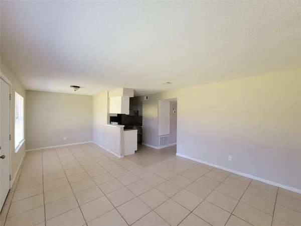 a view of kitchen with refrigerator cabinets and window