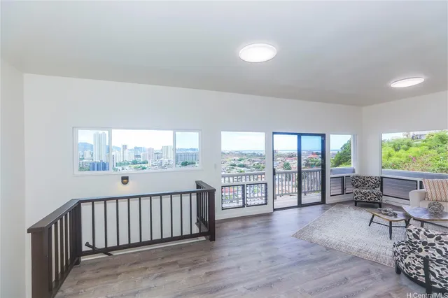 a view of a room with wooden floor and iron stairs