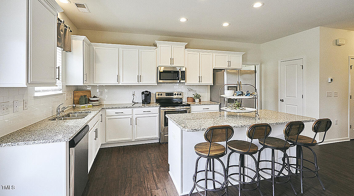 1733 Post Oak Drive Haw River, NC 27258 - Photo 10 of 26 a kitchen with stainless steel appliances granite countertop a white cabinets and a stove top oven