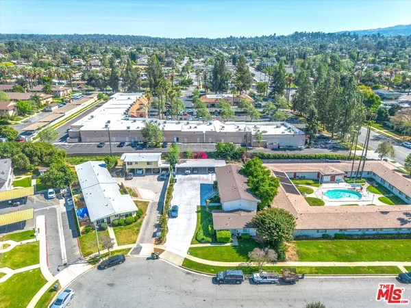 an aerial view of residential houses with outdoor space and parking