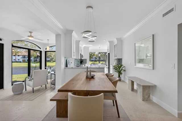 a dining room with wooden floor a chandelier a wooden table and chairs