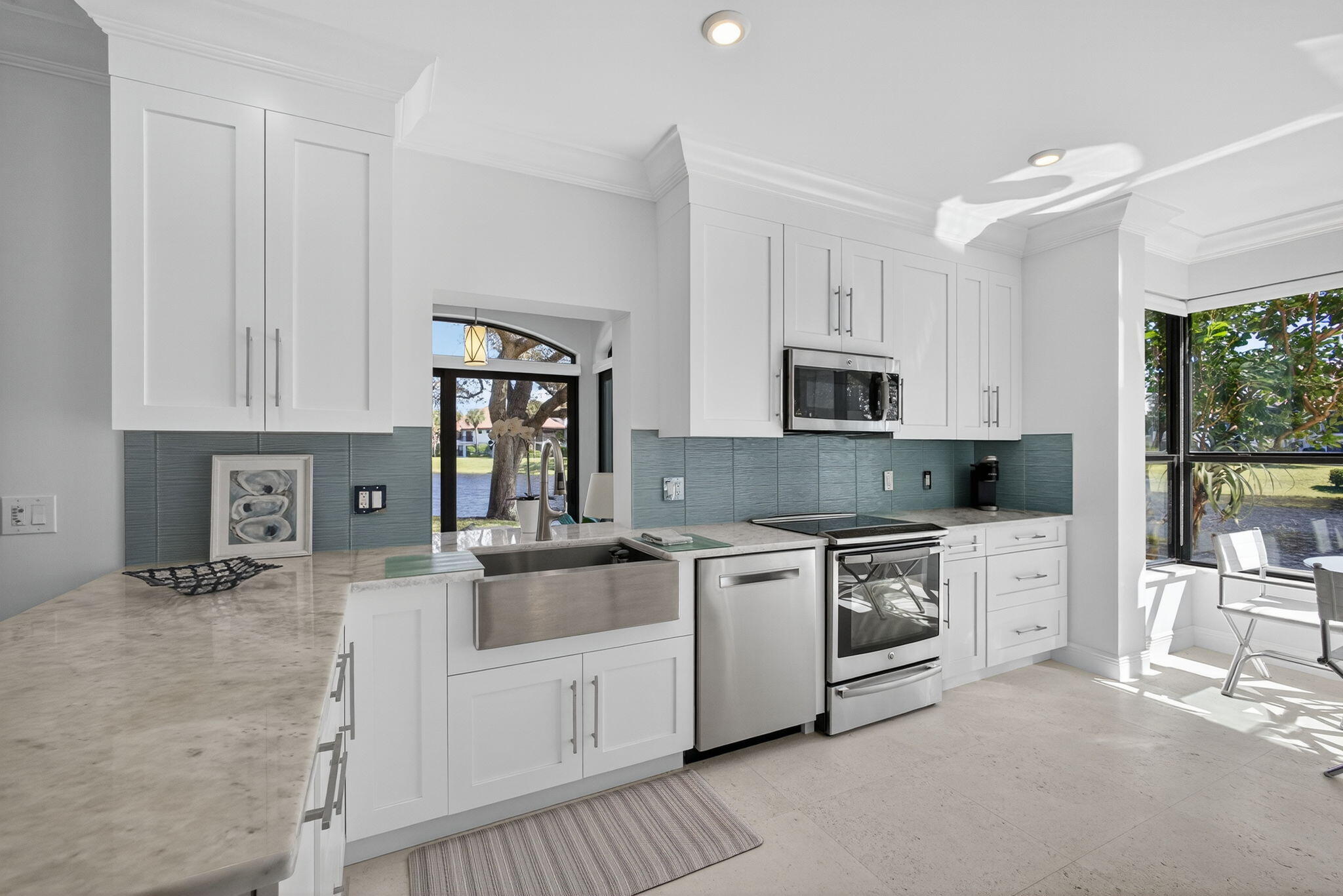 16050 West Bay Drive, Unit 155 Jupiter, FL 33477 - Photo 22 of 51 a kitchen with white cabinets and stainless steel appliances