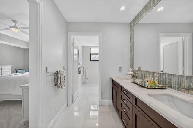 a spacious bathroom with a double vanity sink a mirror and shower