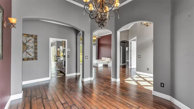 a living room with couches and kitchen view with wooden floor