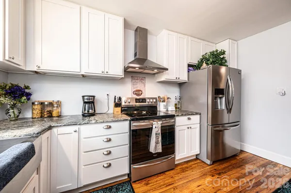 a kitchen with stainless steel appliances granite countertop a stove a refrigerator and a refrigerator