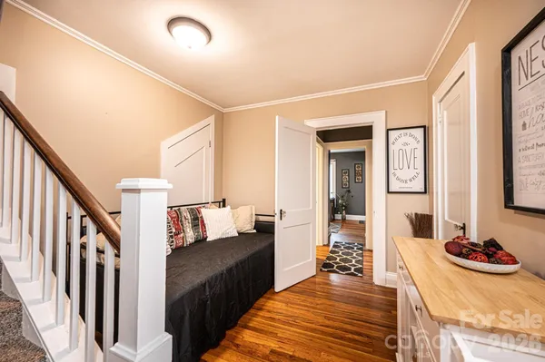 a view of a hallway with wooden floor and a dining room