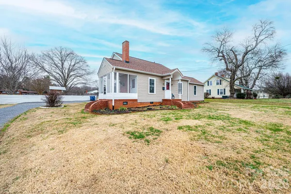 a front view of a house with a yard covered with snow