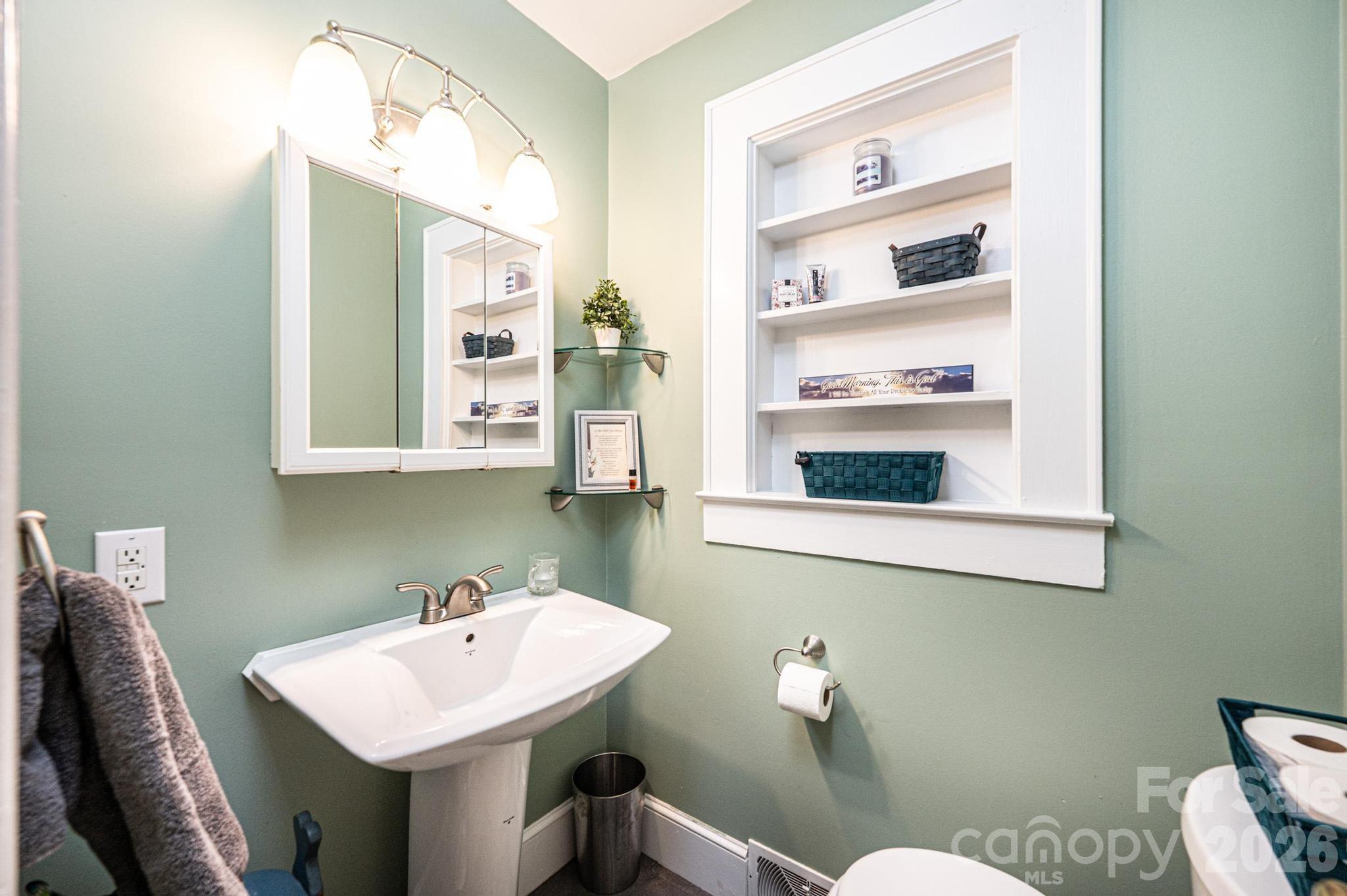 235 Spring Street Mocksville, NC 27028 - Photo 24 of 41 a bathroom with a sink a toilet and mirror