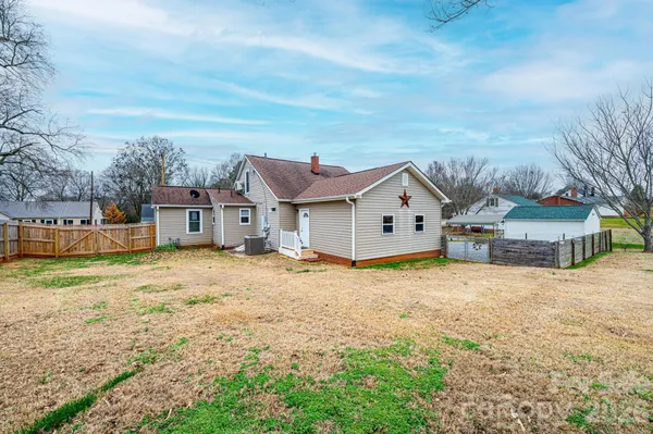 a view of a house with backyard and trees