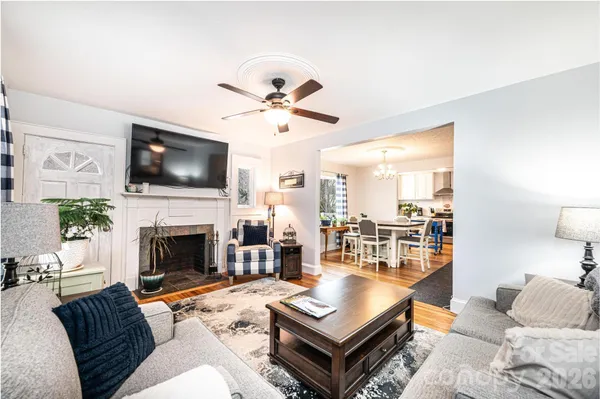 a living room with furniture a fireplace and a flat screen tv