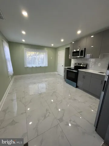 a large kitchen with stainless steel appliances a large counter top