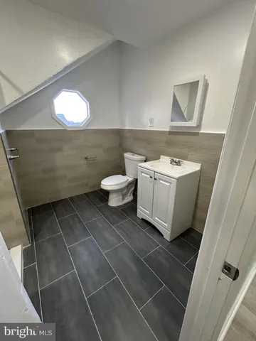 a bathroom with a toilet a sink and mirror