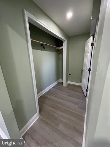 an empty room with wooden floor and entrance