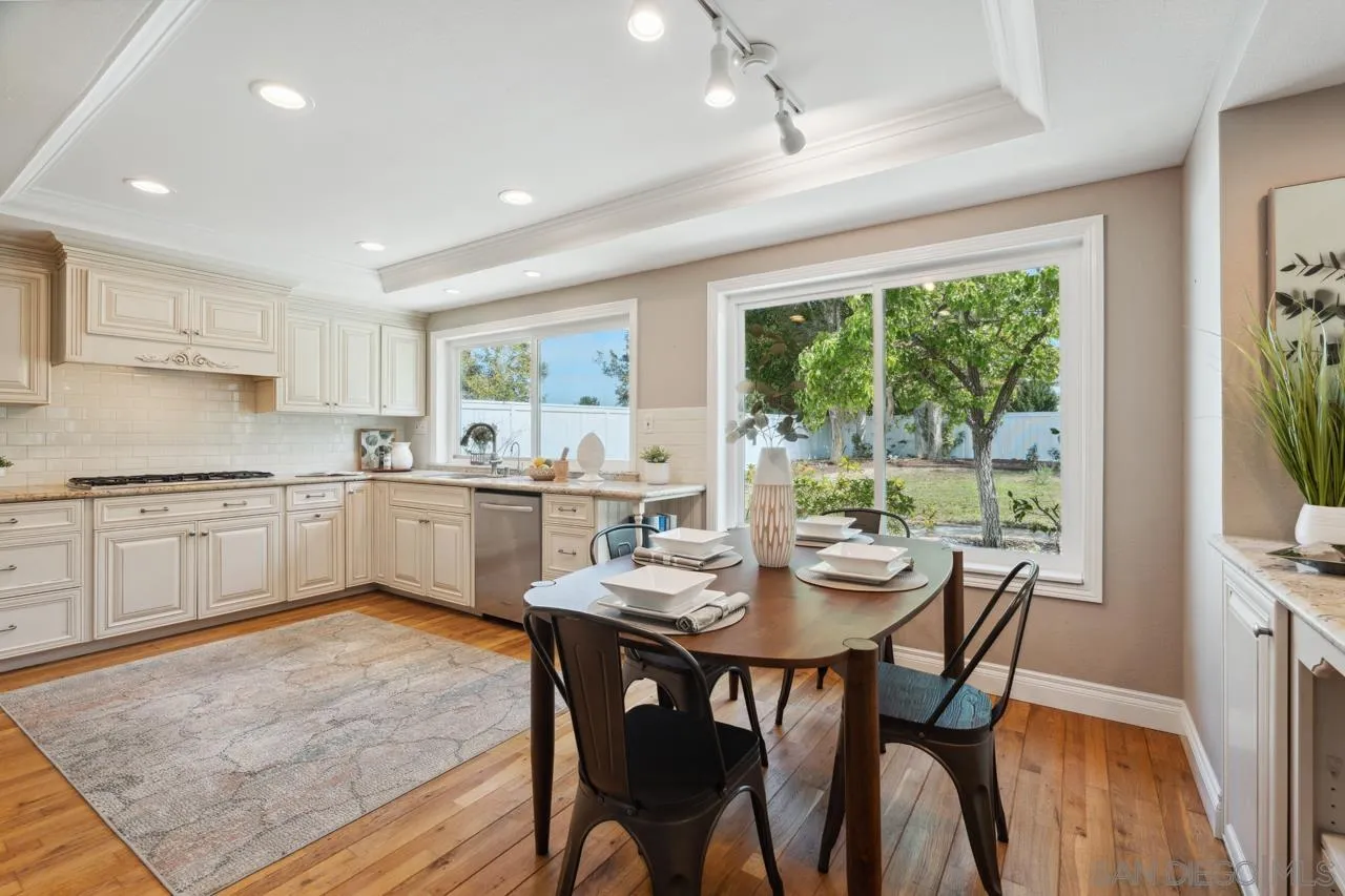 7914 Corte Cardo Carlsbad, CA 92009 - Photo 14 of 61 a kitchen with a dining table chairs and white cabinets