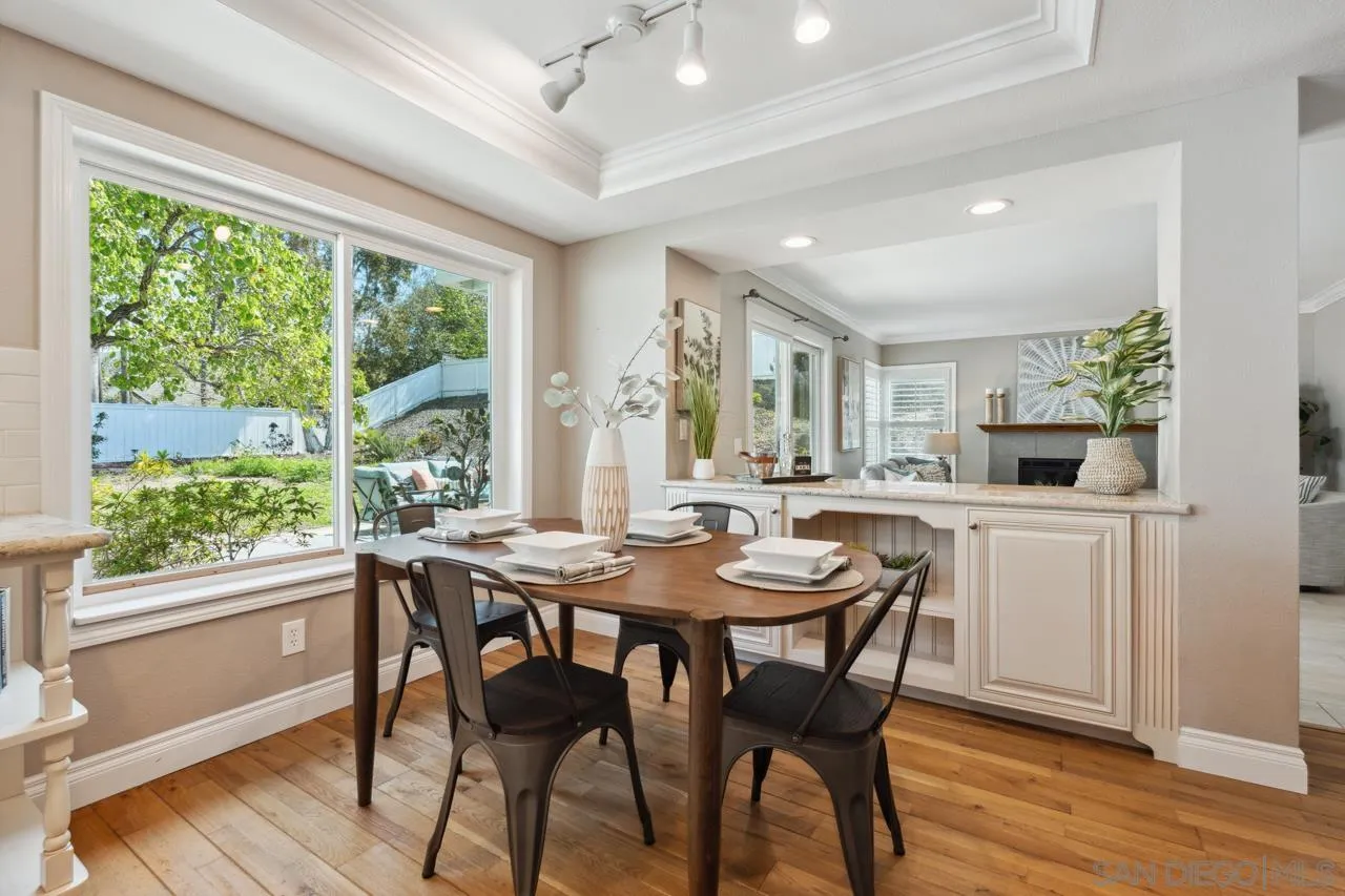 7914 Corte Cardo Carlsbad, CA 92009 - Photo 15 of 61 a kitchen with a table chairs and wooden floor