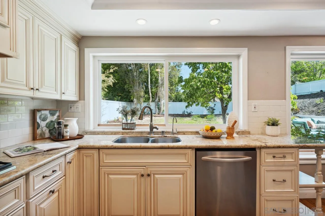 7914 Corte Cardo Carlsbad, CA 92009 - Photo 18 of 61 a kitchen with kitchen island granite countertop a sink window and cabinets