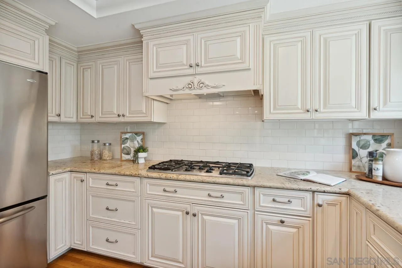 7914 Corte Cardo Carlsbad, CA 92009 - Photo 19 of 61 a kitchen with granite countertop white cabinets and stainless steel appliances