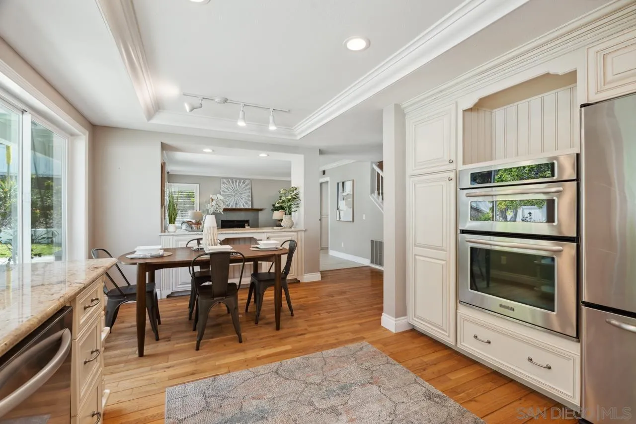 7914 Corte Cardo Carlsbad, CA 92009 - Photo 20 of 61 a view of a dining room with furniture window and wooden floor