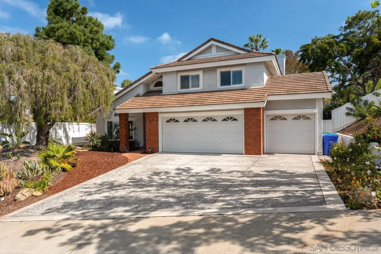 7914 Corte Cardo Carlsbad, CA 92009 - Photo 2 of 61 a front view of a house with a yard and garage