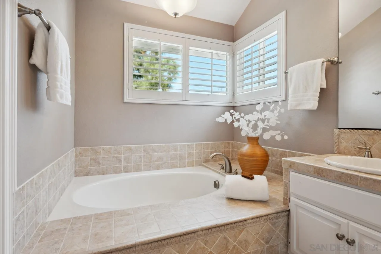 7914 Corte Cardo Carlsbad, CA 92009 - Photo 34 of 61 a bathroom with a tub sink and mirror