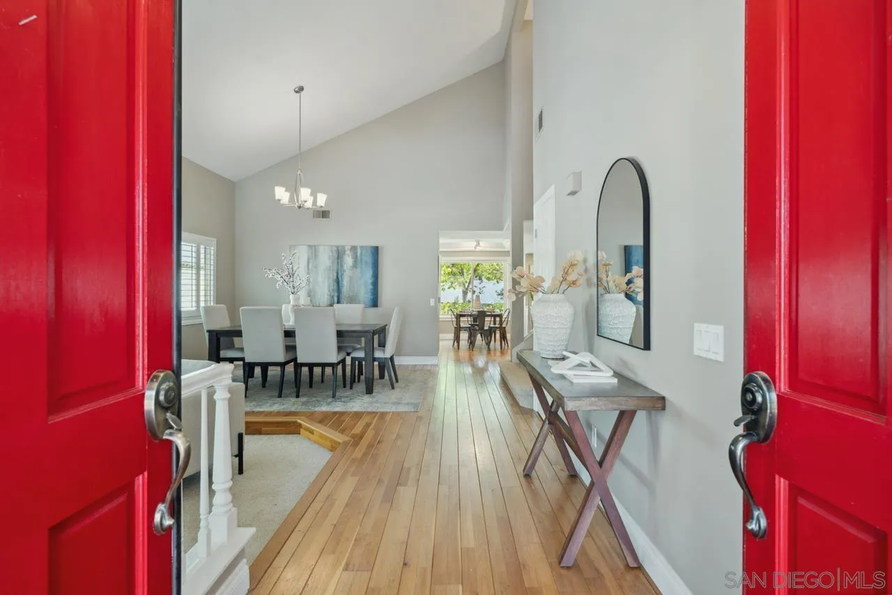 7914 Corte Cardo Carlsbad, CA 92009 - Photo 4 of 61 a view of a dining room with furniture a chandelier and wooden floor