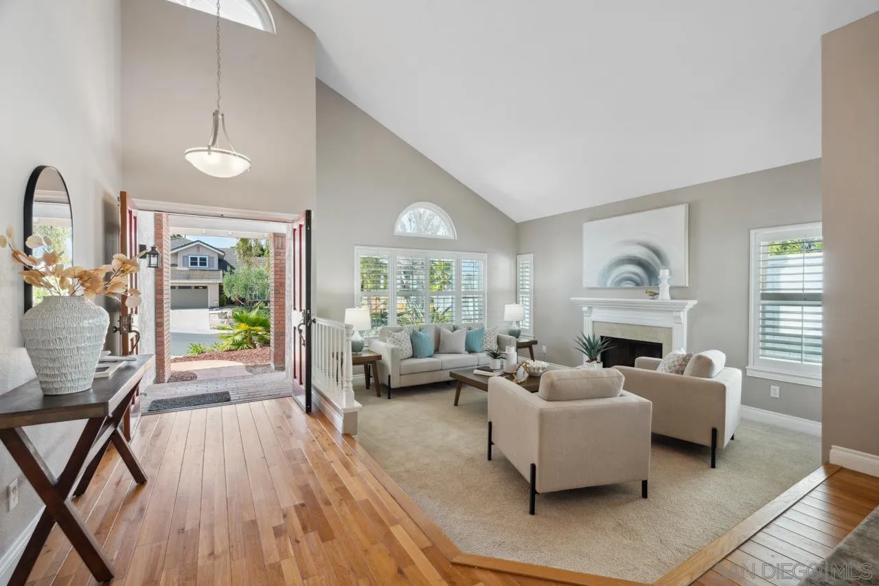 7914 Corte Cardo Carlsbad, CA 92009 - Photo 6 of 61 a living room with furniture a fireplace and a floor to ceiling window