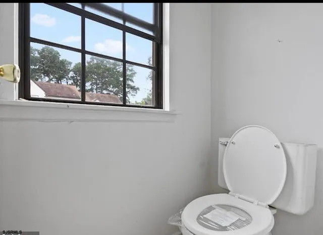 a white toilet sitting next to a window