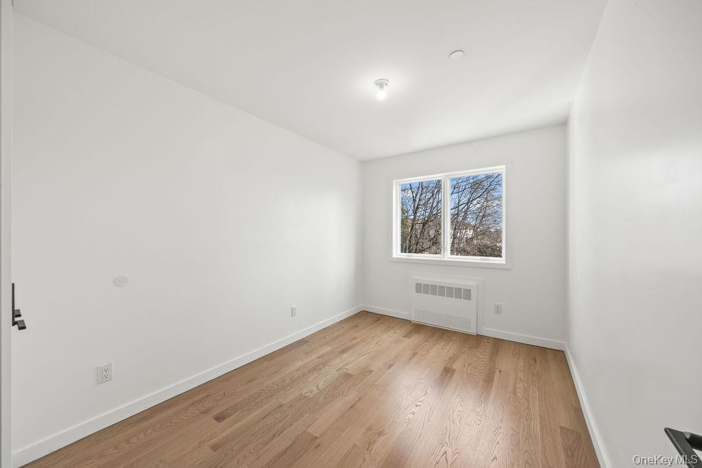 62 Blauvelt Road, Unit 202 Monsey, NY 10952 - Photo 30 of 34 an empty room with wooden floor and windows