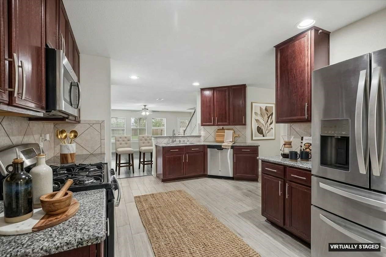 15642 South Fall Fern Circle Houston, TX 77044 - Photo 4 of 32 a kitchen with stainless steel appliances granite countertop a stove a sink dishwasher a refrigerator and a microwave oven