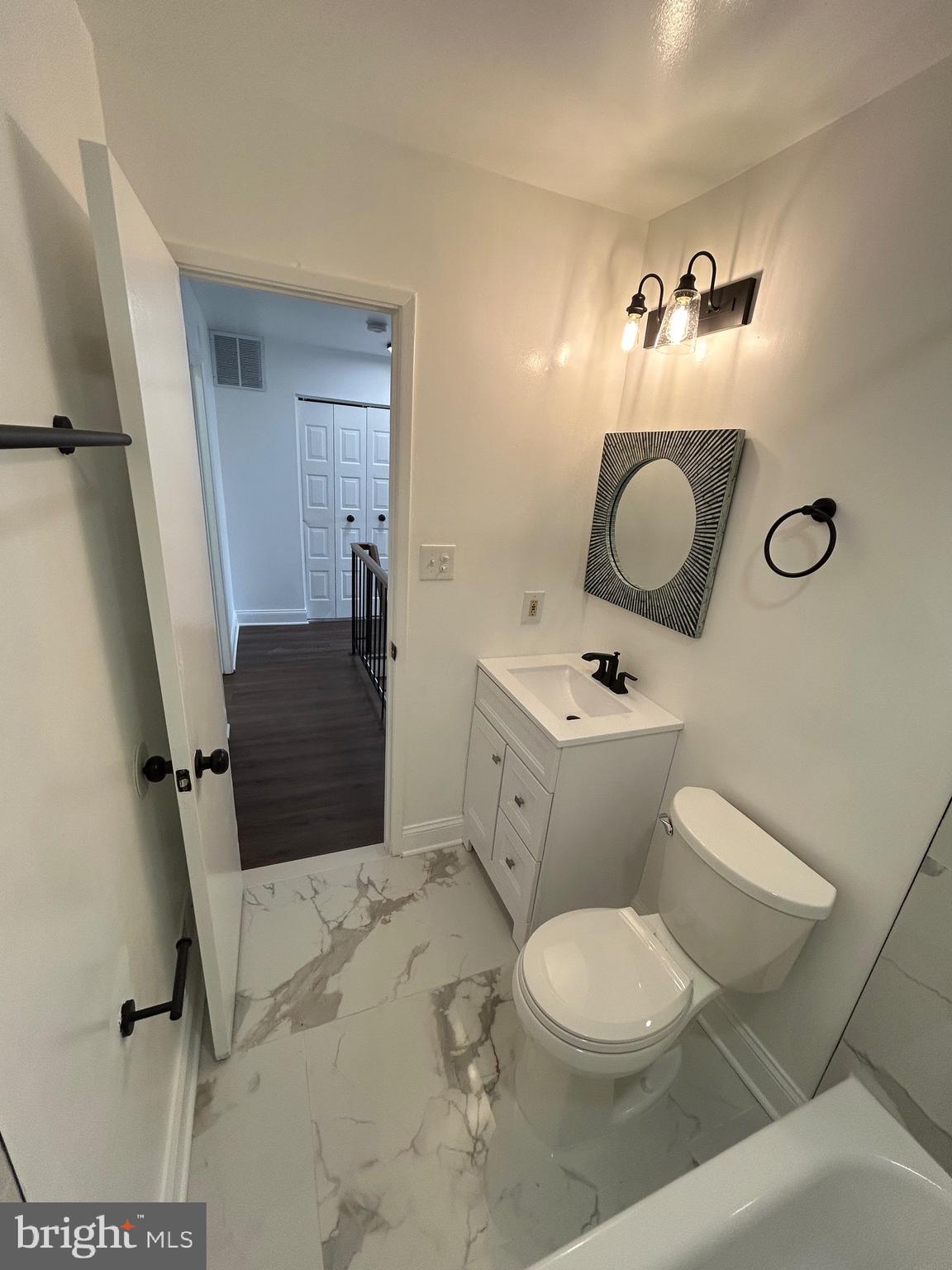 7036 Palamar Terrace Lanham, MD 20706 - Photo 17 of 34 a bathroom with a toilet a sink and mirror