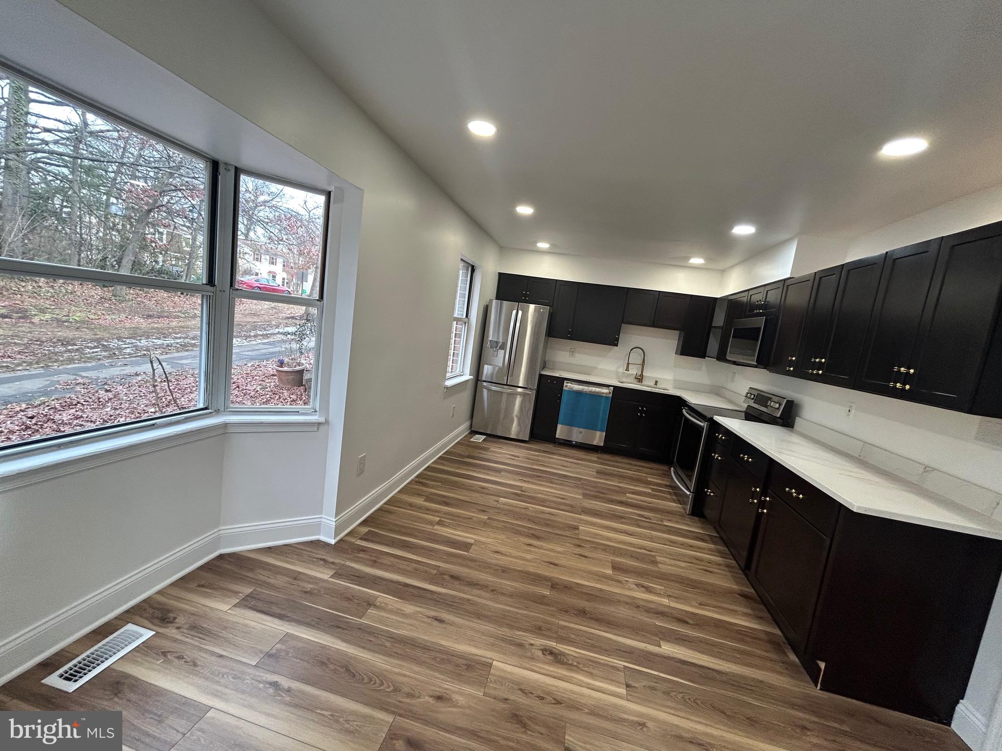 7036 Palamar Terrace Lanham, MD 20706 - Photo 2 of 34 a large kitchen with kitchen island a large counter top space a sink stainless steel appliances and cabinets