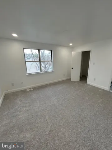 an empty room with windows and closet