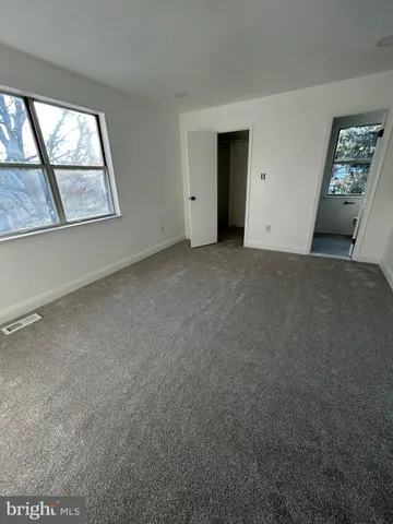 an empty room with windows and closet