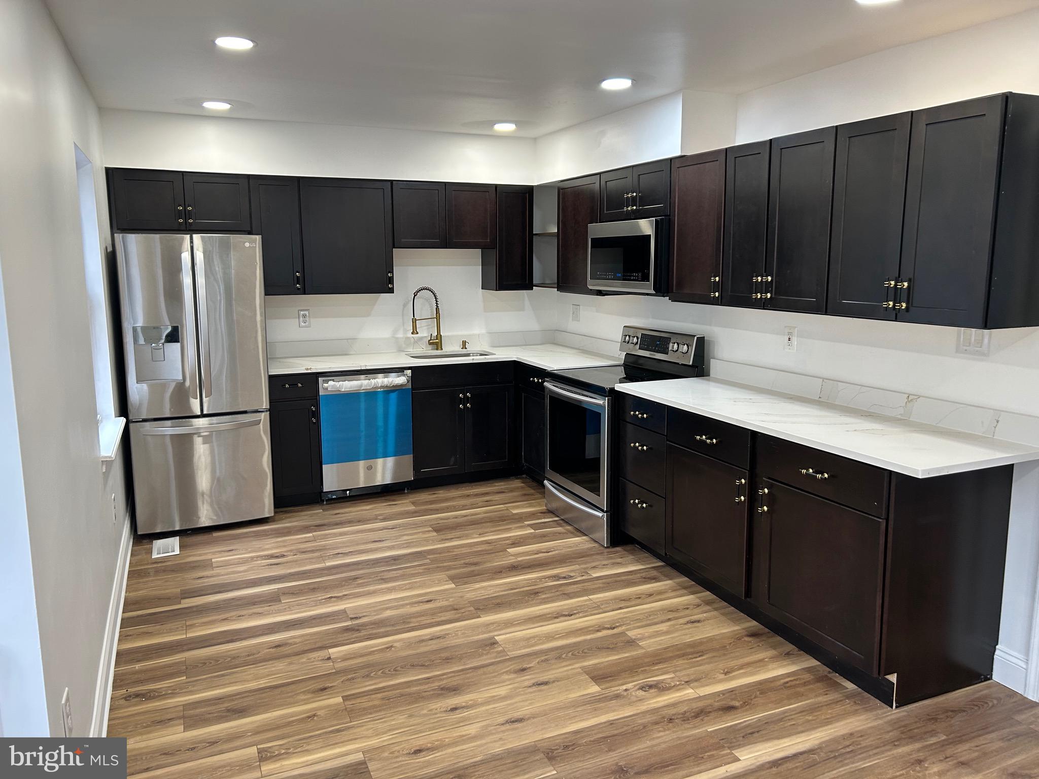 7036 Palamar Terrace Lanham, MD 20706 - Photo 5 of 34 a kitchen with stainless steel appliances granite countertop a sink refrigerator and cabinets