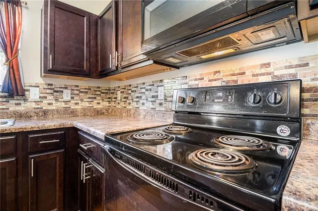 a stove top oven sitting inside of a kitchen