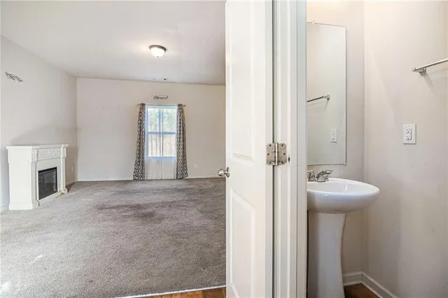 a view of an empty room with a fireplace and a window