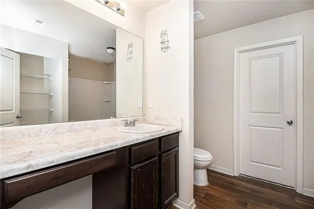 a bathroom with a granite countertop sink a toilet and shower