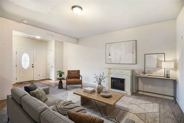 a living room with furniture a fireplace and a large mirror