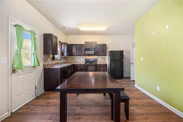 a kitchen with stainless steel appliances granite countertop a stove a refrigerator a sink a stove and island with wooden floor