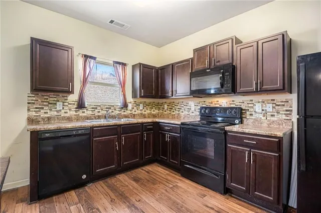 a kitchen with stainless steel appliances wooden cabinets and a sink
