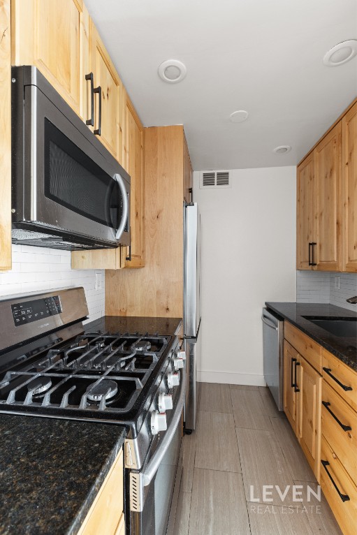 333 East 14th Street, Unit 9A Manhattan, NY 10003 - Photo 3 of 8 a kitchen with a stove and a microwave