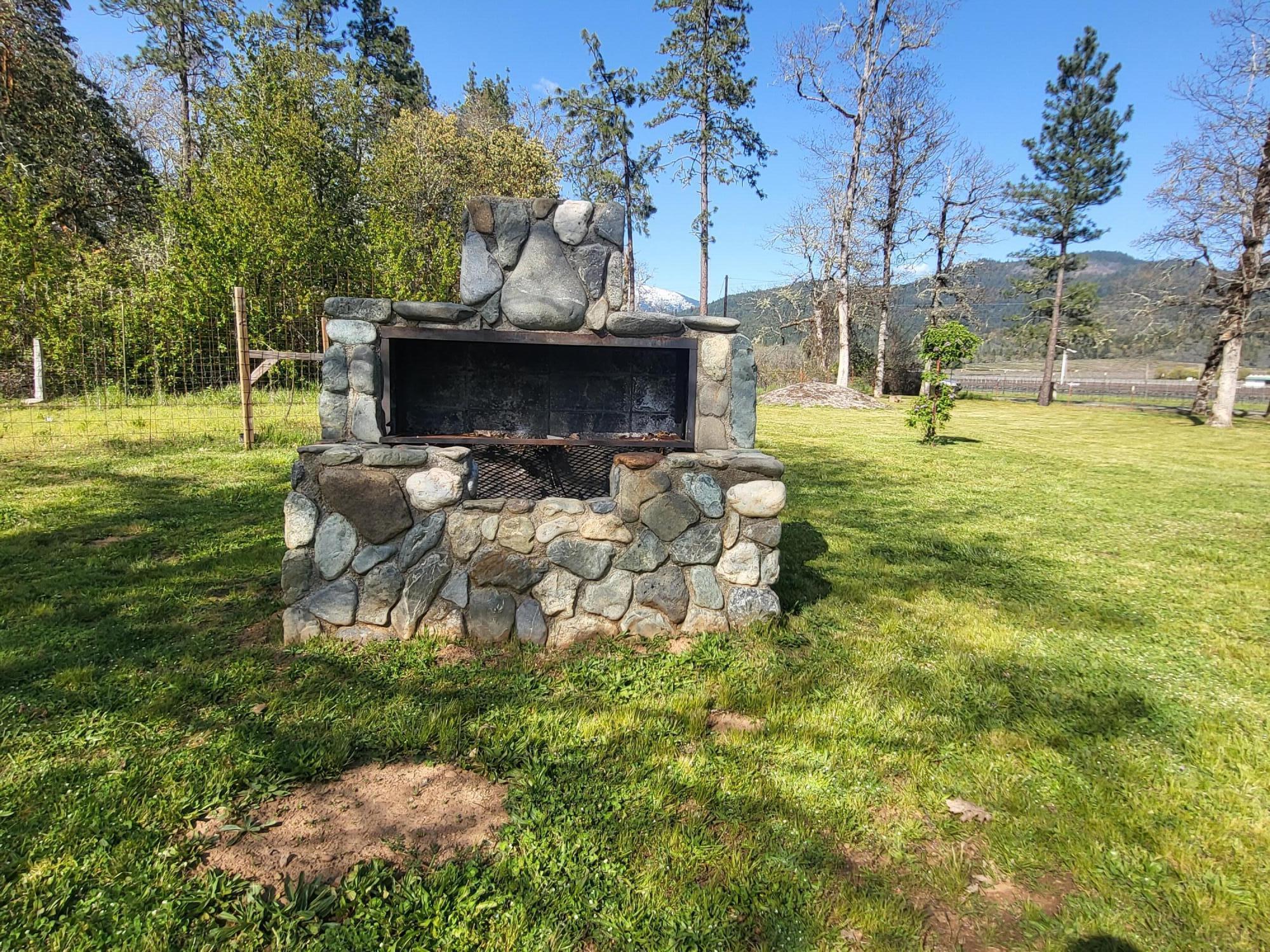 7750 Holland Loop Road Cave Junction, OR 97523 - Photo 10 of 12 a garden with trees in the background