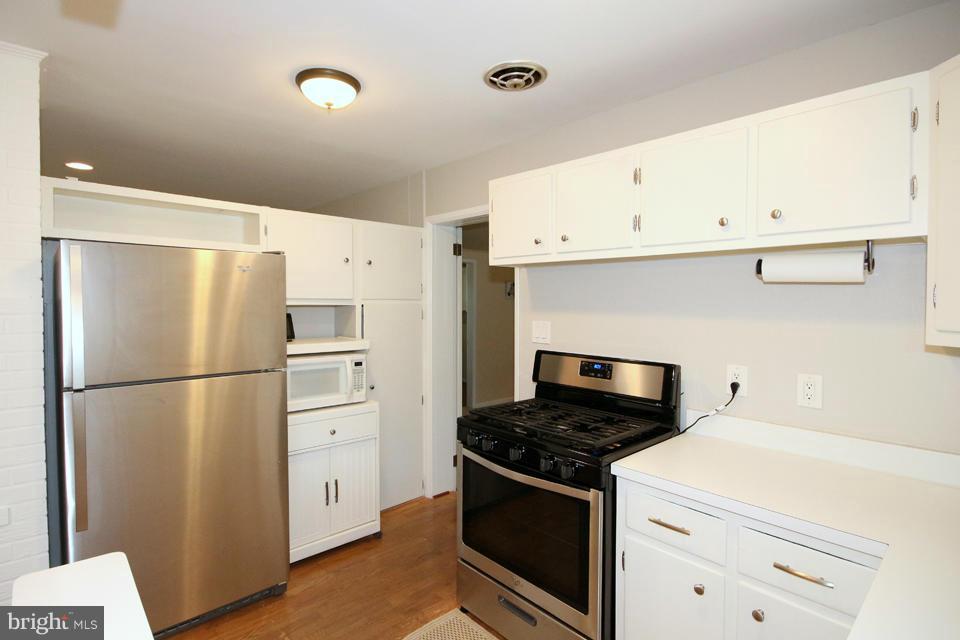 5216 Dalton Road Springfield, VA 22151 - Photo 4 of 27 a kitchen with a refrigerator stove and white cabinets